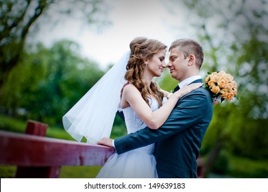 Beautiful Wedding Couple In Park. Kiss And Hug Each Other