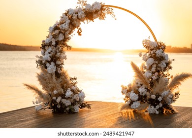 Beautiful wedding decoration at sunset. Wedding ceremony venue. Round arch, white chairs, cute, fashionable decor. Part of holiday decor, flower arrangement. - Powered by Shutterstock