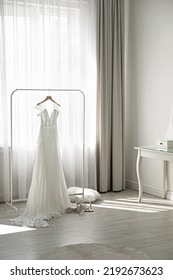 Beautiful Wedding Dress Hanging On Clothing Rack In Room