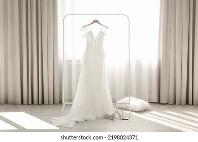 Beautiful Wedding Dress Hanging On Clothing Rack In Room