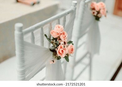 Beautiful wedding flower peach roses decorations on white tiffany chair