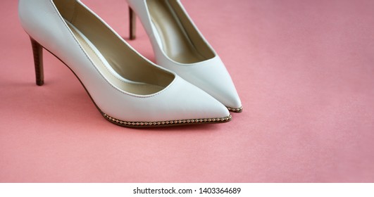 Beautiful Wedding Shoes On A High And Thin Gold Stiletto. Luxurious Designer Wedding Shoes On A Pink Table.