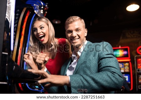 Beautiful and Well Dressed Friends Playing Automat Machine in the Casino and Celebrate