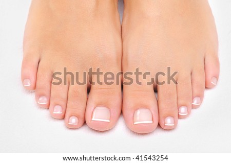 Beautiful well-groomed female feet with the French pedicure