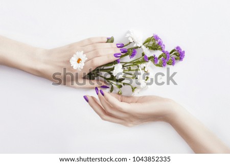 Beautiful well-groomed hands with wild flowers on the table, anti-aging and anti-wrinkle cosmetics for hands. Skin care and beauty, skin hydration and Spa