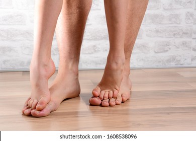 Beautiful well-groomed male legs. Male pedicure with small girl feets. Healthcare concept