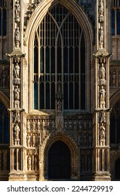 Beautiful west wing of Beverley Minster with large stained glass window, ancient door, and partial view of towers with stone carvings in Beverley, Yorkshire, UK. - Shutterstock ID 2244729919