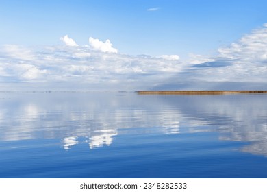 Beautiful white blue clouds over lake, symmetric sky background, cloudscape on lake Ik, Russia. Nature abstract, cloudy sky reflected on water, calm windless weather, natural environment, skyline - Powered by Shutterstock