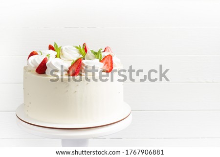 Beautiful white cake decoraited with meringue and fresh strawberries. White background