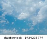 Beautiful white clouds on blue sky background. Nature photography. Elegant blue sky picture in sunlight. Big or tiny and soft white fluffy clouds in the blue sky. Coudy blue sky background