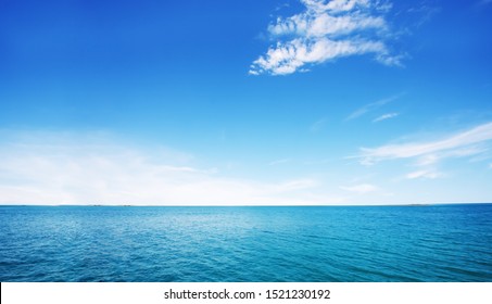 Beautiful white clouds on blue sky over calm sea with sunlight reflection in sea . The day when the sea waves calm, clear sky.