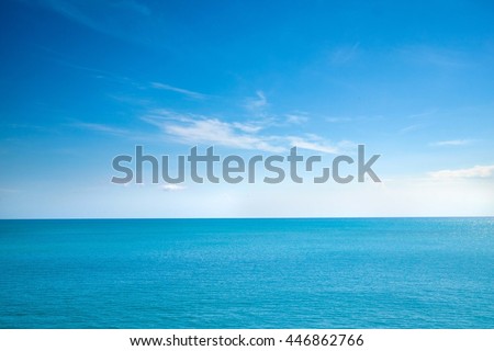 Beautiful white clouds on blue sky over calm sea with sunlight reflection, Bali Indonesia. Tranquil sea harmony of calm water surface. Sunny sky and calm blue ocean. Vibrant sea with clouds on horizon