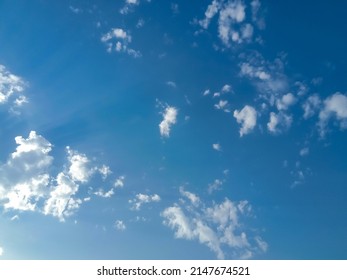 Beautiful White Clouds On Deep Blue Sky Background. Elegant Blue Sky Picture In Daylight. Small Thin Soft White Fluffy Clouds In The Blue Sky Background. Cumulus Clouds In Clear Blue Sky. No Focus