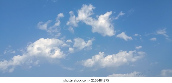 Beautiful White Clouds On Deep Blue Sky Background. Elegant Blue Sky Picture In Daylight. Tiny Small Soft White Clouds In The Blue Sky Background. Cumulus Clouds In Clear Blue Sky. No Focus