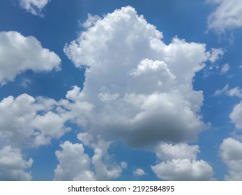 Beautiful White Clouds On Deep Blue Sky Background. Elegant Blue Sky Picture In Daylight. Large Bright Soft Fluffy Clouds Are Cover The Entire Blue Sky. Cumulus Clouds Against Blue Sky. No Focus