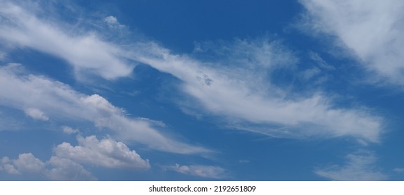 Beautiful White Clouds On Deep Blue Sky Background. Elegant Blue Sky Picture In Daylight. Large Bright Soft Fluffy Clouds Are Cover The Entire Blue Sky. Cumulus Clouds Against Blue Sky. No Focus