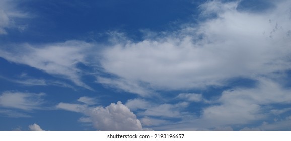 Beautiful White Clouds On Deep Blue Sky Background. Elegant Blue Sky Picture In Daylight. Large Bright Soft Fluffy Clouds Are Cover The Entire Blue Sky. Cumulus Clouds Against Blue Sky. No Focus