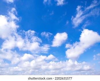 Beautiful White Clouds On Deep Blue Sky Background. Elegant Blue Sky Picture In Daylight. Tiny Small Soft White Clouds In The Blue Sky Background. Cumulus Clouds In Clear Blue Sky. No Focus