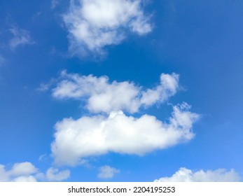 Beautiful White Clouds On Deep Blue Sky Background. Elegant Blue Sky Picture In Daylight. Tiny Small Soft White Clouds In The Blue Sky Background. Cumulus Clouds In Clear Blue Sky. No Focus