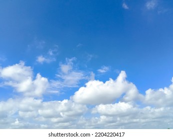 Beautiful White Clouds On Deep Blue Sky Background. Elegant Blue Sky Picture In Daylight. Tiny Small Soft White Clouds In The Blue Sky Background. Cumulus Clouds In Clear Blue Sky. No Focus