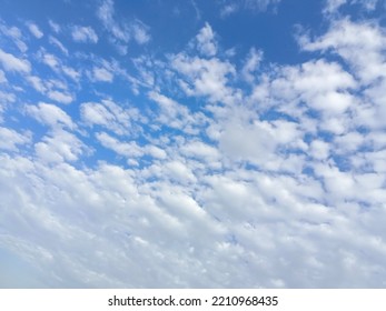 Beautiful White Clouds On Deep Blue Sky Background. Elegant Blue Sky Picture In Daylight. Tiny Small Soft White Clouds In The Blue Sky Background. Cumulus Clouds In Clear Blue Sky. No Focus