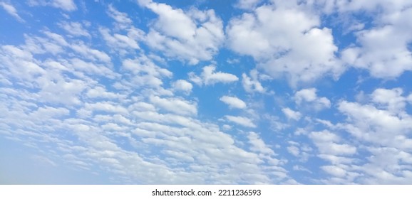 Beautiful White Clouds On Deep Blue Sky Background. Elegant Blue Sky Picture In Daylight. Tiny Small Soft White Clouds In The Blue Sky Background. Cumulus Clouds In Clear Blue Sky. No Focus