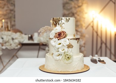 Beautiful white and gold wedding cake with flowers