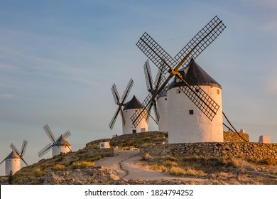 Beautiful white spanish windmill on the hill at fairy sunset near the castle in Consuegra, Toledo province, Spain