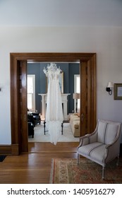 Beautiful White Wedding Dress Hanging In Historic Old Home