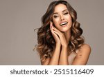 Beautiful white-toothed smiling woman   with long  and   shiny wavy  hair .  Beauty happy model girl with curly hairstyle . Gorgeous white teeth in a smile