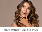 Beautiful white-toothed smiling woman   with long  and   shiny wavy  hair .  Beauty happy model girl with curly hairstyle . Gorgeous white teeth in a smile