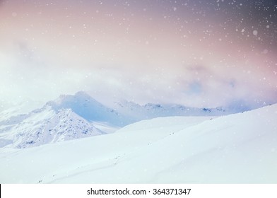 Beautiful winter landscape with snow-covered mountains at sunset.