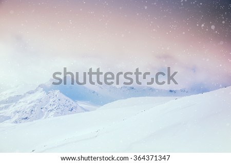 Beautiful winter landscape with snow-covered mountains at sunset.
