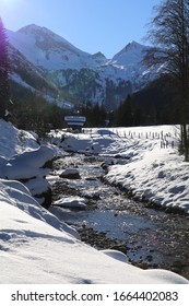 beautiful winter landscape with sun, snow, mountains and a clear mountain river