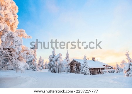 Beautiful winter landscape with wooden hut and snow covered trees in Lapland Finland