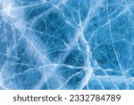 Beautiful winter natural blue ice texture of surface of frozen Baikal Lake in cold day. Nature abstract pattern of white cracks. Winter seasonal background, mock up, flat lay, blank, closeup, top view