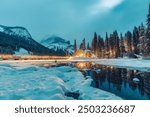 Beautiful winter scene of wooden lodge glowing on Emerald Lake and pine forest at Yoho national park, British Columbia, Canada