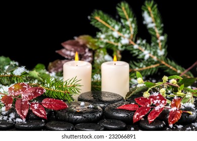 beautiful winter spa concept of zen basalt stones with drops, lilac candles, beads and evergreen branches