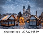 Beautiful winter view of the old town square of Prague, Czech Republic, with a christmas market and the famous Tyn Church with snow