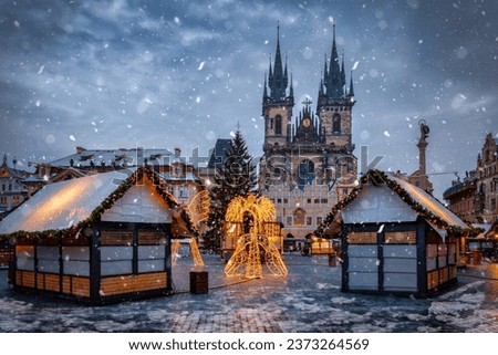 Beautiful winter view of the old town square of Prague, Czech Republic, with a christmas market and the famous Tyn Church with snow