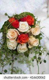 Beautiful Winter Wedding Bouquet - With Creme And Orange Roses And Some Greens. Natural Light. Selective Focus. 