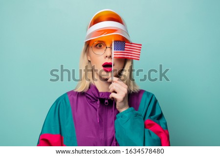 Beautiful woman in 90s sport suit in glasses with USA flag on blue background