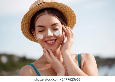 Beautiful woman applying cream sunscreen on tanned face. Sunscreen. Skin and body care. The girl uses a sunscreen for her skin. Portrait of a female holding suntan lotion and moisturizing sunscreen. - Powered by Shutterstock