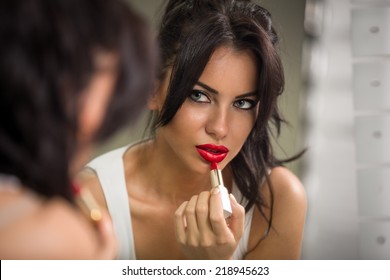 Beautiful Woman Applying Red Lipstick