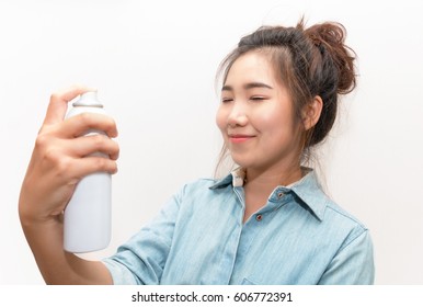 Beautiful woman applying spray natural water treatment on face