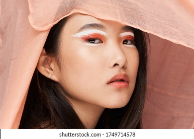 Beautiful woman Asian appearance bright makeup pink fabric