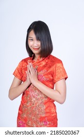 A Beautiful Woman Of Asian Descent Wearing A Red Dress. Posing For A Photo Shoot In A Studio, White Background