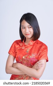 A Beautiful Woman Of Asian Descent Wearing A Red Dress. Posing For A Photo Shoot In A Studio, White Background