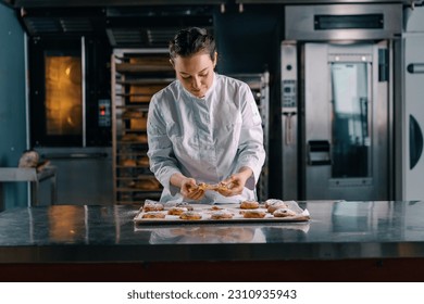 beautiful woman baker tears ready freshly baked hot aromatic buns checks dough bakery production - Powered by Shutterstock