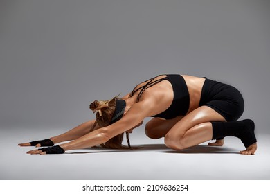 Beautiful Woman Ballet Dancer In Black Swimsuit Posing On Light Grey Studio Background. Animal Instinct